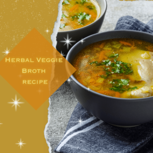 A glistening bowl of veggie soup has floating carrots and cilantro on top.